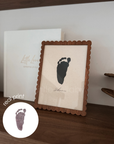 Framed black footprint on a textured background with real footprint