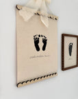 Canvas print with footprints and a bow on a white wall