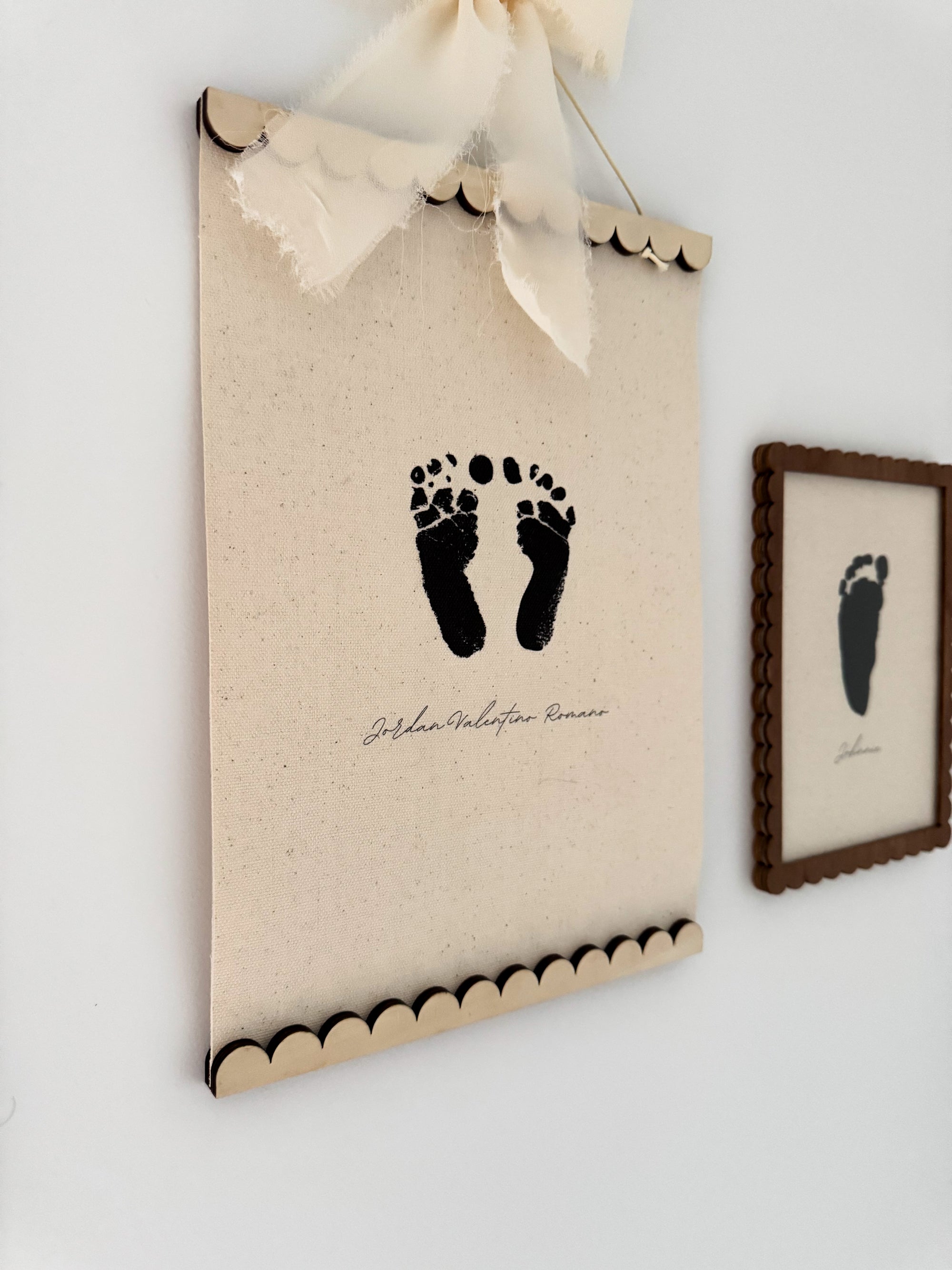 Canvas print with footprints and a bow on a white wall